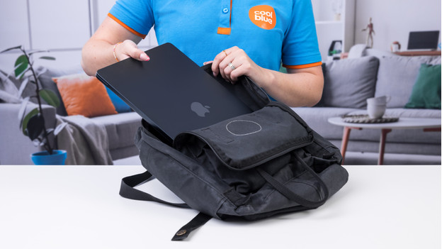 Spécialiste met le MacBook Air 15" dans son sac à dos.