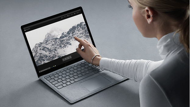 Vrouw tikt op touchscreen Surface Laptop. 