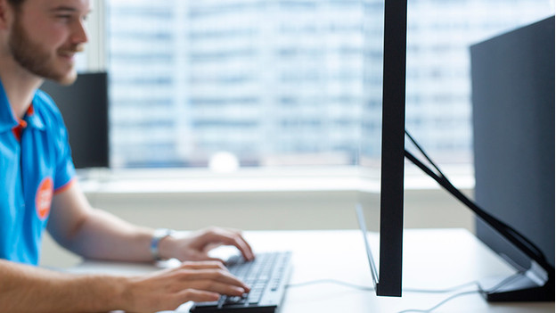 Expert working on a business monitor, photo from the side