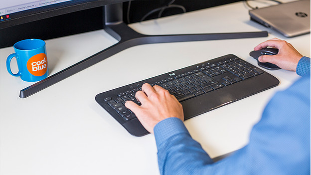 Un homme travaille avec une souris et un clavier.