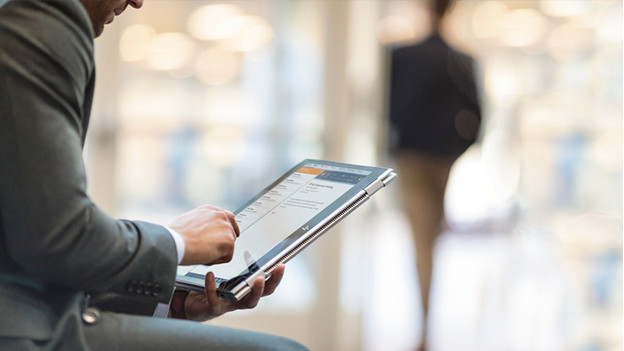 Un homme utilise un ordinateur portable 2-en-1 à écran tactile avec un support de tablette