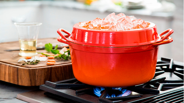 Dutch oven on gas stove with ice cubes in lid