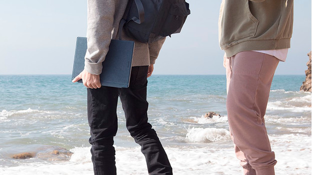 Un homme avec un ordinateur portable sur la plage