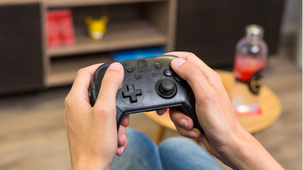 Jongen geeft meisje Nintendo Switch controller. 