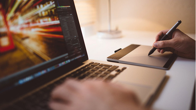 Personne qui travaille avec Adobe Photoshop via une tablette graphique.