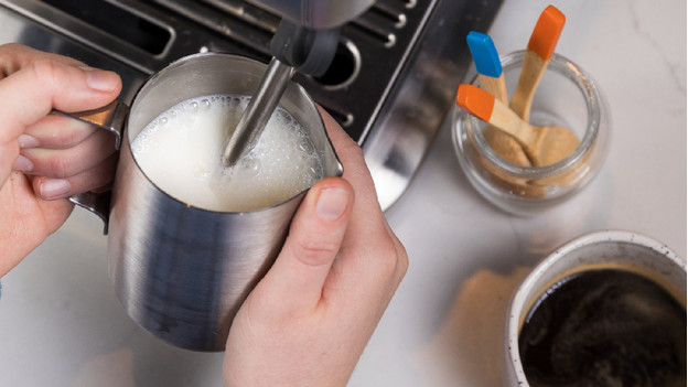 buse vapeur dans pichet rempli de lait
