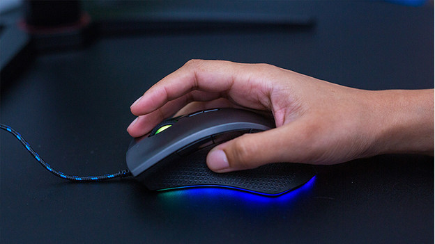 Main de femme sur une souris gamer.