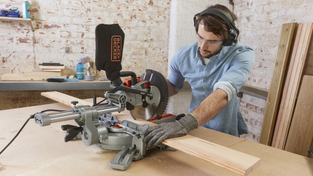 Person cuts plank with BLACK+DECKER radial arm saw