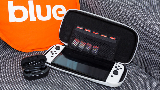 A Nintendo Switch OLED in a travel case with games