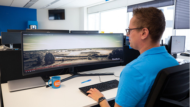 Spécialiste au travail sur un écran PC ultralarge