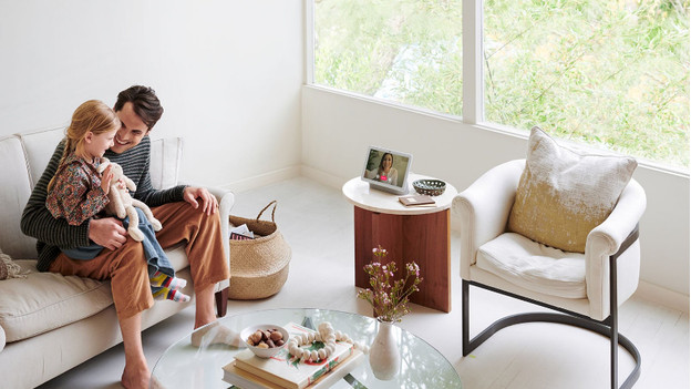 Google home hub on the table in front of family smart home