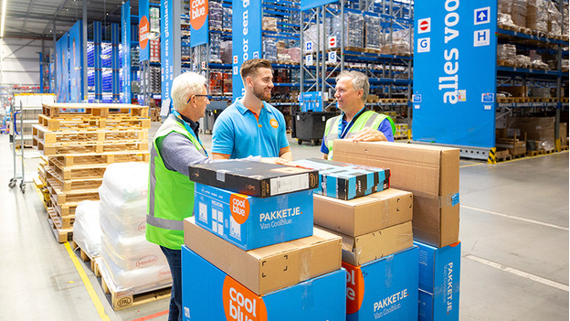 3 hommes dans l'entrepôt coolblue avec commande d'ordinateur portable