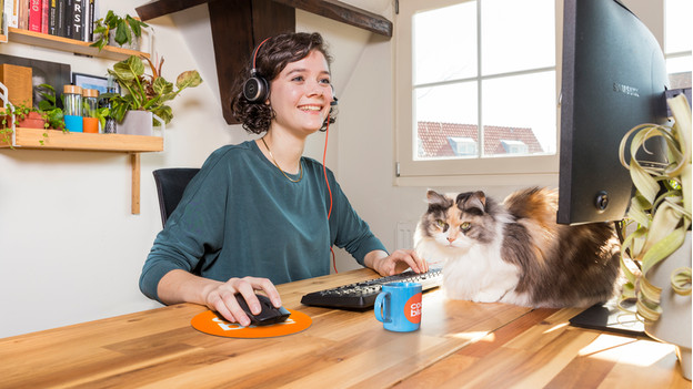 Une femme travaille avec un casque de bureau sur un bureau