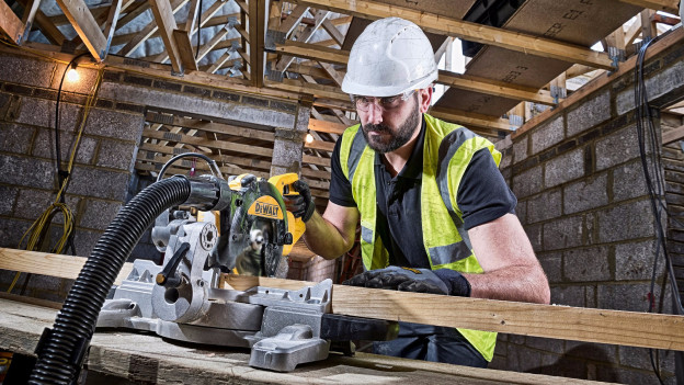 Professional uses radial arm saw on construction site