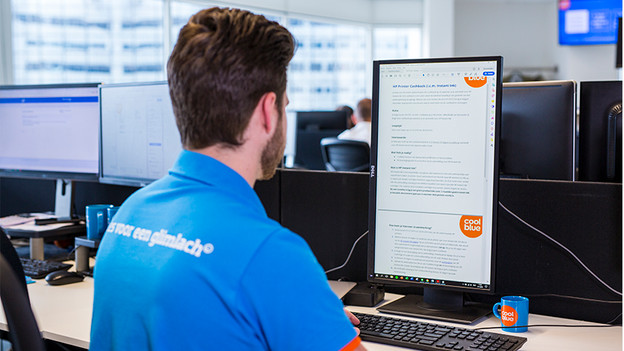 Man working at the Coolblue office behind a vertical monitor.