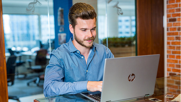 Le garçon travaille derrière un ordinateur portable HP au bureau.