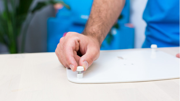 Quelqu'un visse les pieds sur la plaque de sol du support pour enceinte BlueBuilt