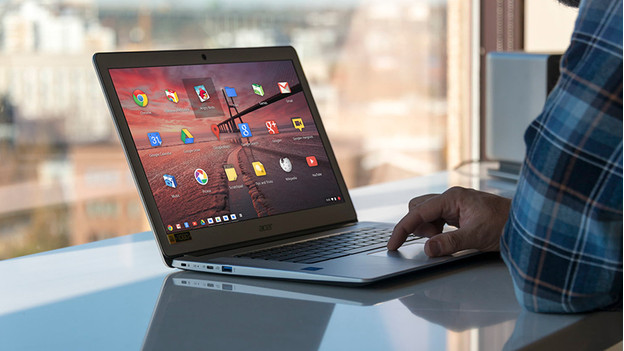 Man works on Chromebook in front of window.