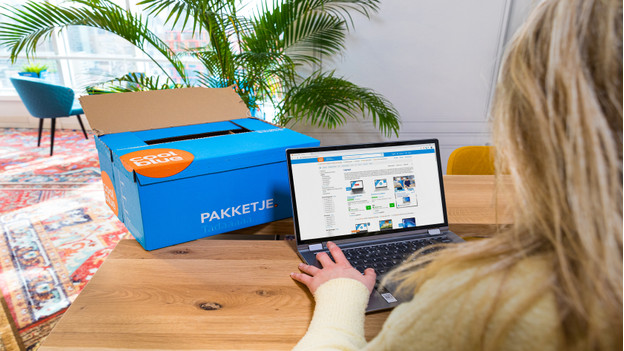 Une dame déballe un PC portable Deuxième Chance sur son bureau