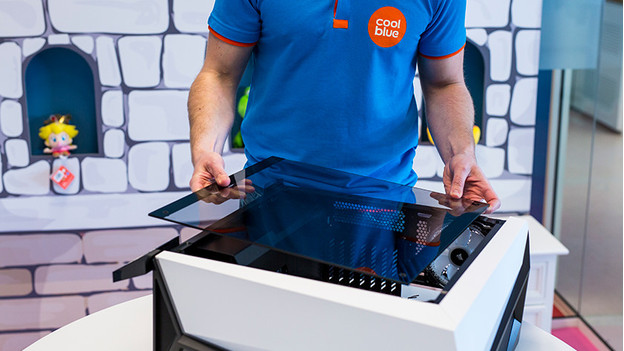 Un homme ouvre un PC de bureau.