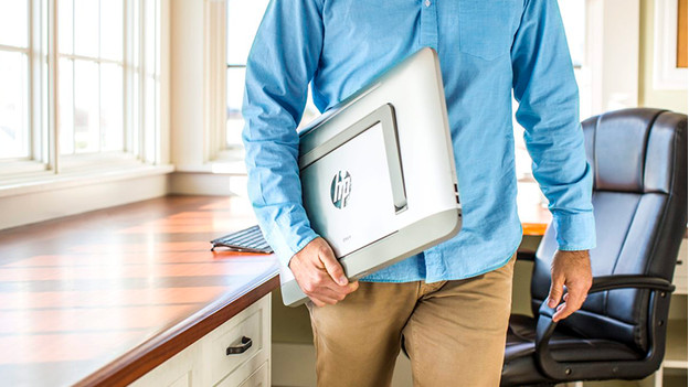 Man carries folded all-in-one under his arm.