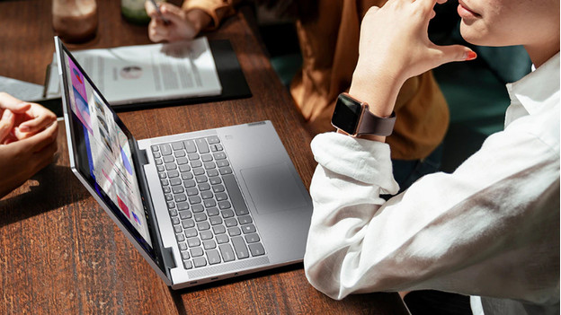 Vrouw zit achter laptop op bureau