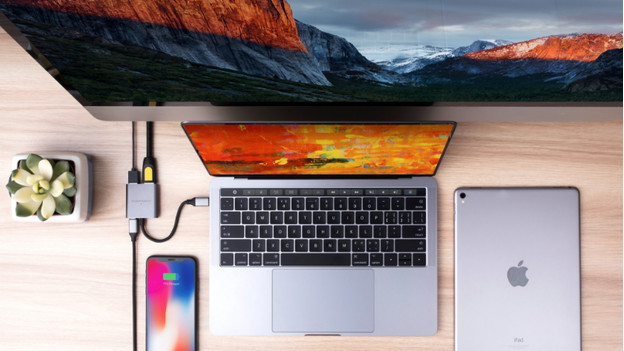 MacBook, iPad, and iPhone on table with docking station and monitor