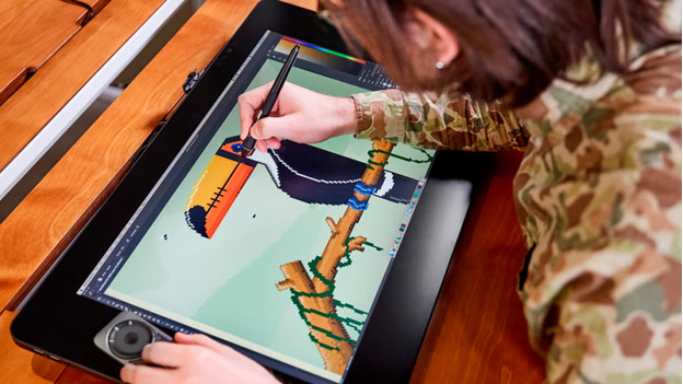 Someone is designing on a drawing tablet with screen