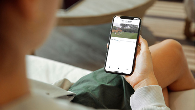 Quelqu'un regarde l'image de la caméra IP via l'appli.