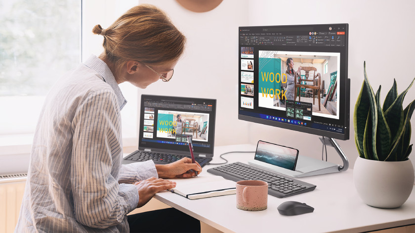 Une femme travaille sur un PC portable 15 pouces avec une tasse à café à côté.