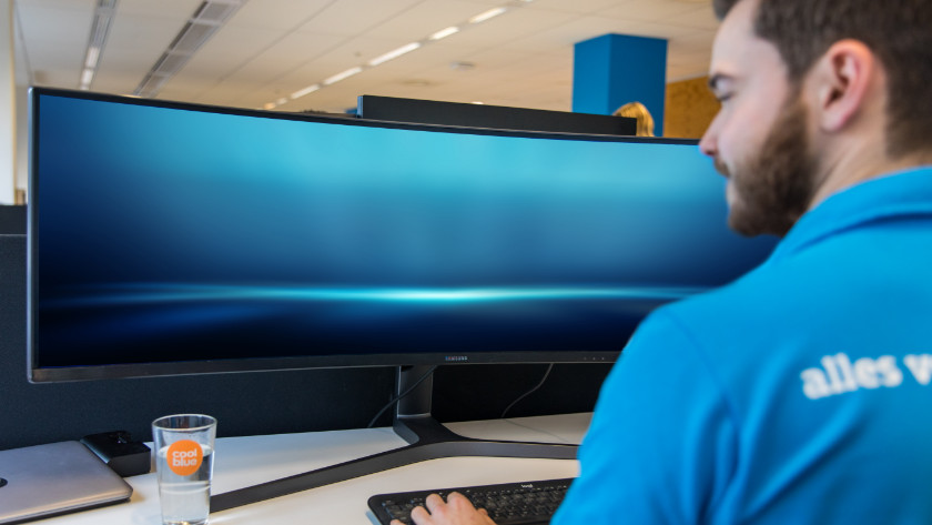 Specialist met een ultrawide monitor en docking station