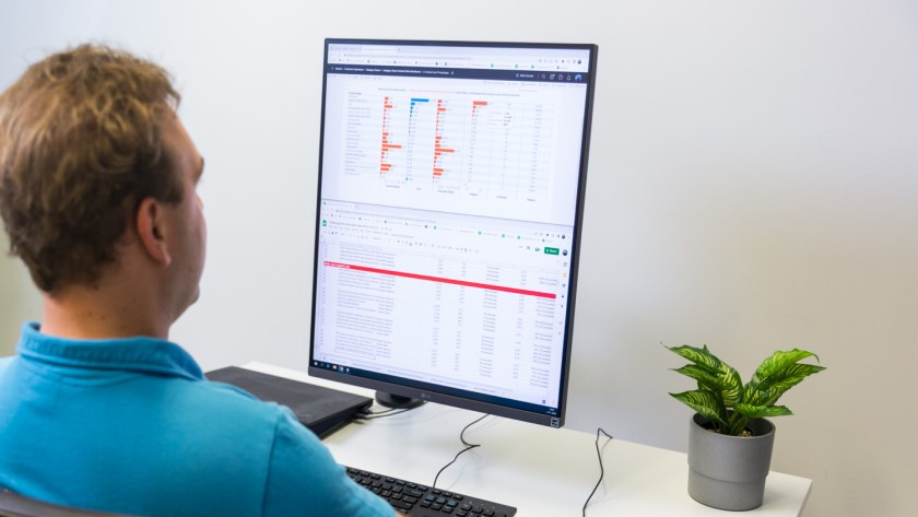 Spécialiste au travail sur un écran PC pour professionnels 4K avec Excel et programme de données placés l'un sous l'autre