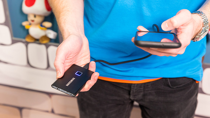 Specialist sluit een smartphone aan op een externe SSD