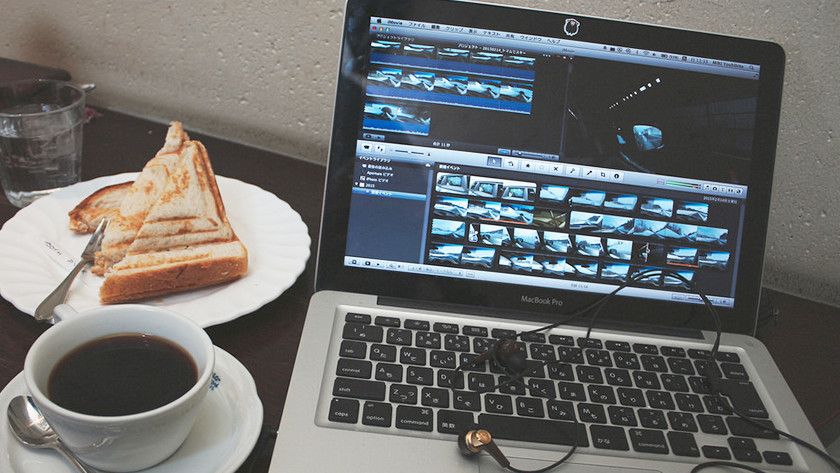 Video's bewerken op een MacBook Pro met een tosti en een kopje koffie. 