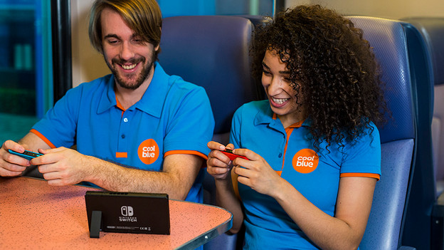 Girl and boy play on Nintendo Switch in the train.