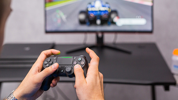 Controller of the PlayStation 4 and F1 2019 on the monitor