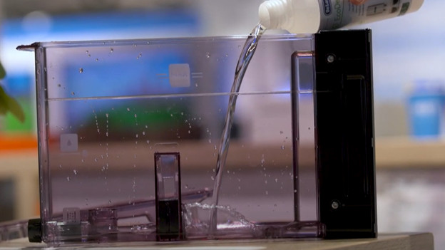 Giet het ontkalkingsmiddel in het waterreservoir