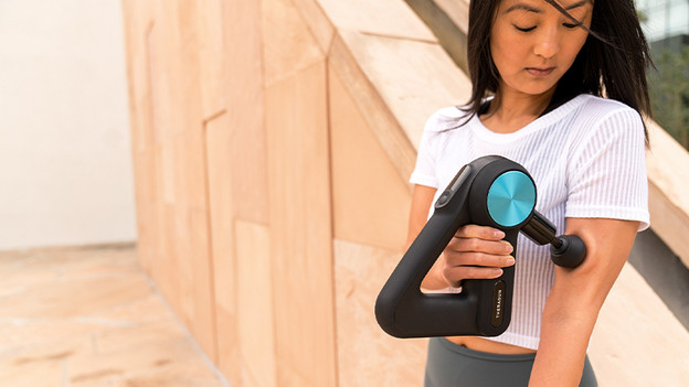 Woman with Theragun massage gun