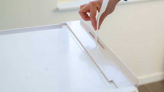 Insert the strap through the middle slot from top to bottom.