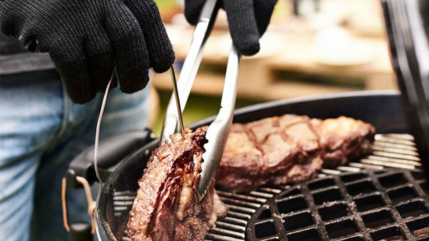 Retourner la viande avec des outils de barbecue