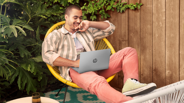 Homme dans un fauteuil avec un HP Pavilion Aero sur les genoux