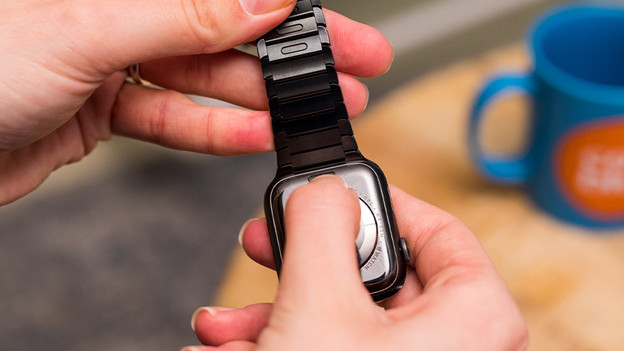 Press the release button on the back of the Apple Watch.