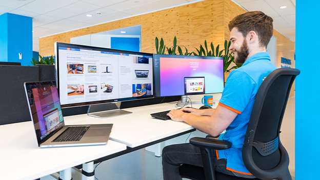 Homme regardant 3 écrans