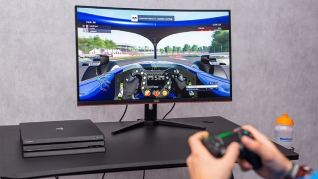 Un spécialiste joue à un jeu de F1 sur un écran PC gamer AOC via une PS4