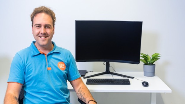 Spécialiste assis à côté de l'écran PC gamer Samsung Odyssey G85