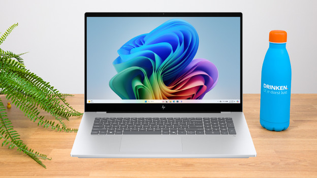 Une femme travaille sur un PC portable 17 pouces avec divers accessoires sur le bureau.