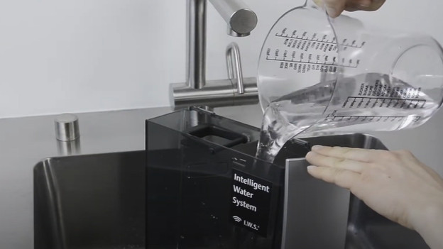 Giet het water in het waterreservoir