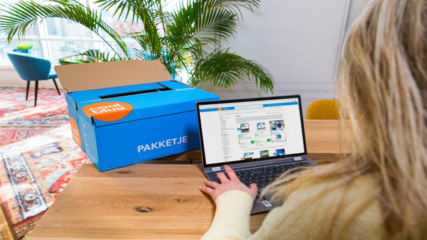 Une dame déballe un PC portable Deuxième Chance sur son bureau