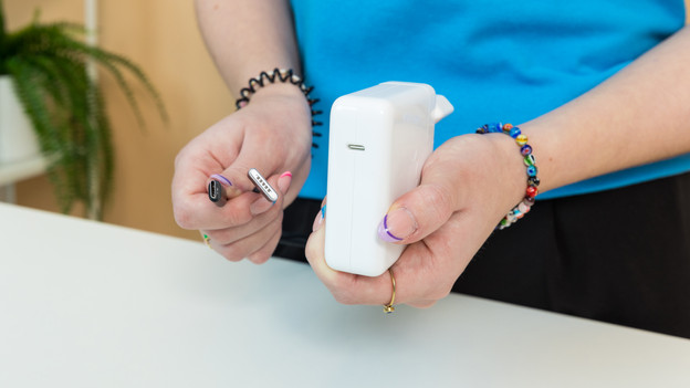 Apple specialist met MacBook oplader en kabel