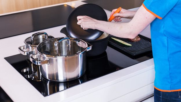 Plusieurs poêles et casseroles sur la plaque de cuisson